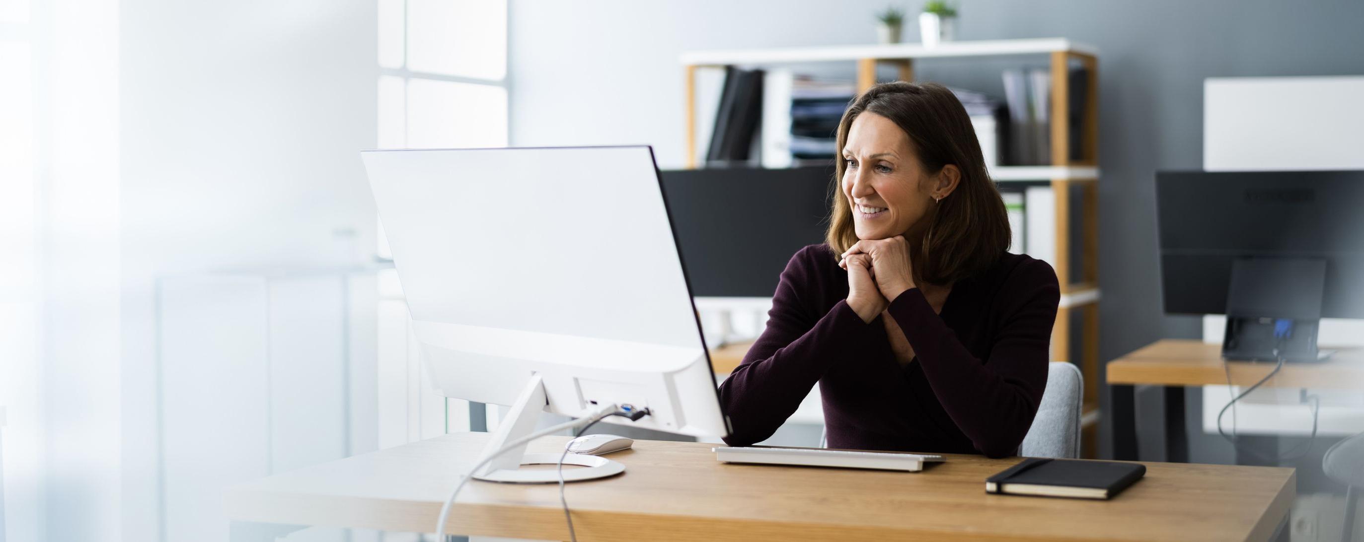 A middle-aged woman watches a Patelco webinar from her computer.